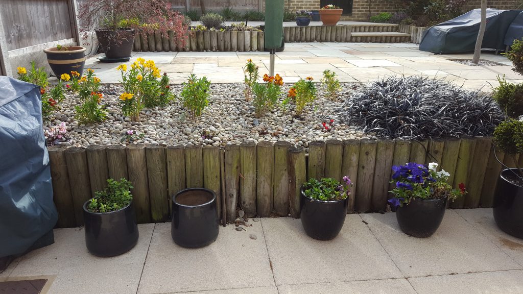 patio-before-with-round-timber-retaining-walls